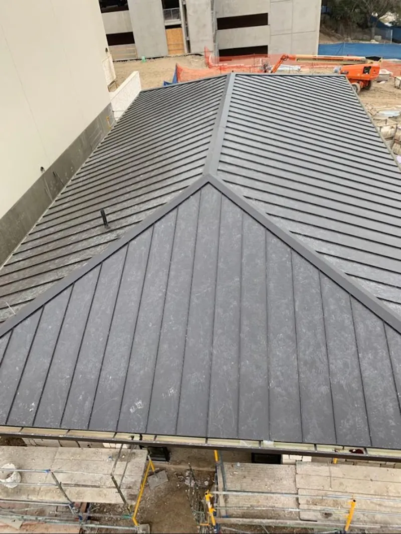 Commercial metal roof construction with crane equipment in Orchard Park