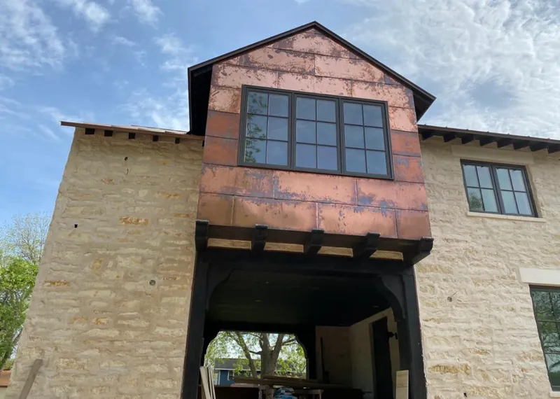 Copper metal panel facade on a stone building for Roof Repair in Orchard Park